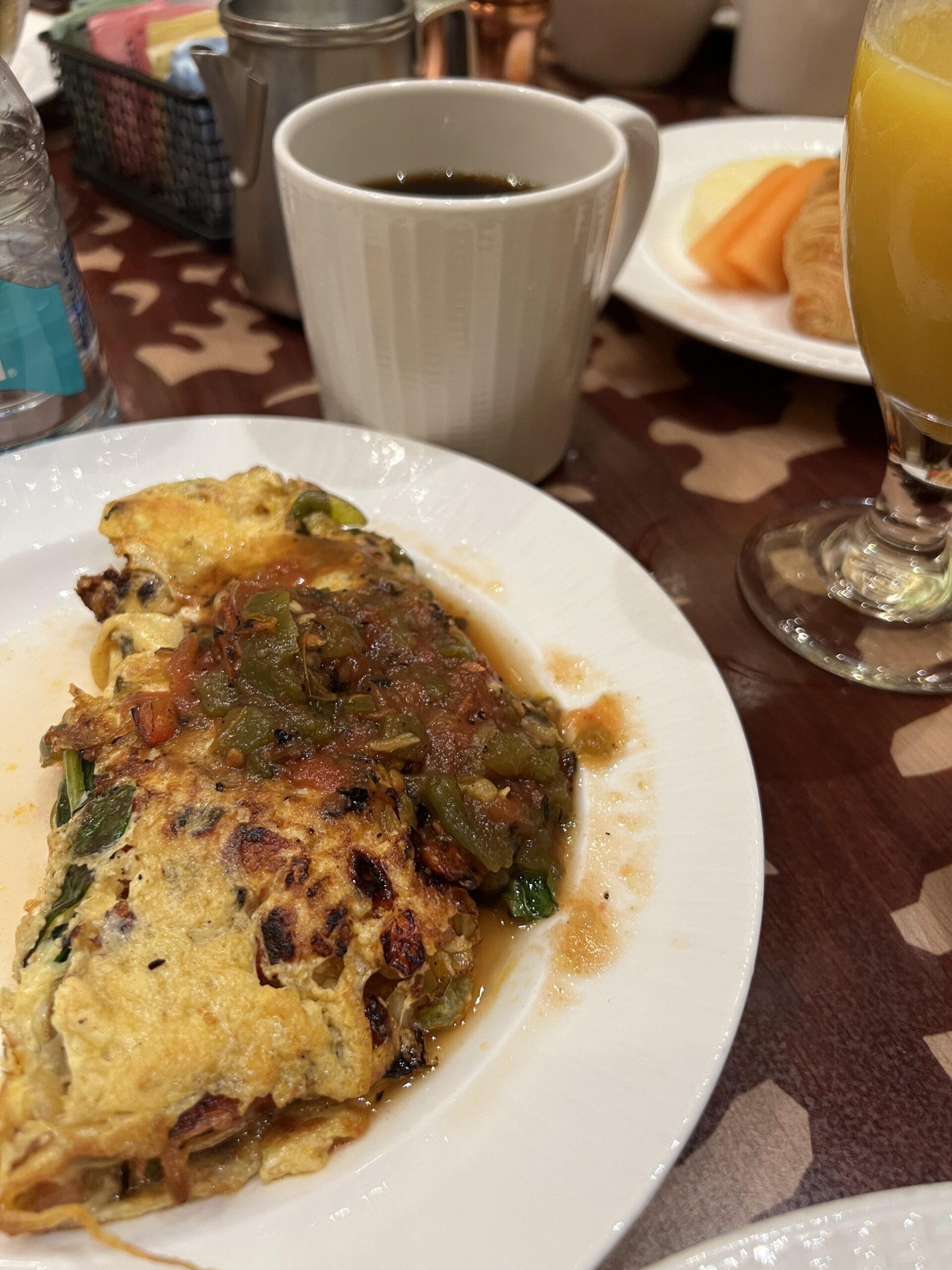 トマトソースをかけたオーダーメイド・オムレツ。ホットコーヒーとオレンジジュースとともに