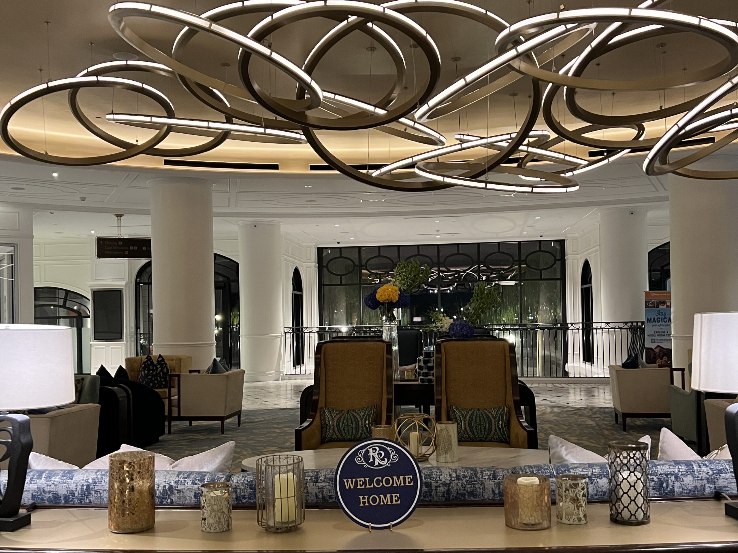 ディズニー・リビエラ・リゾートのロビー(夜)。WELCOME HOME サインと天井のアートライトが印象的