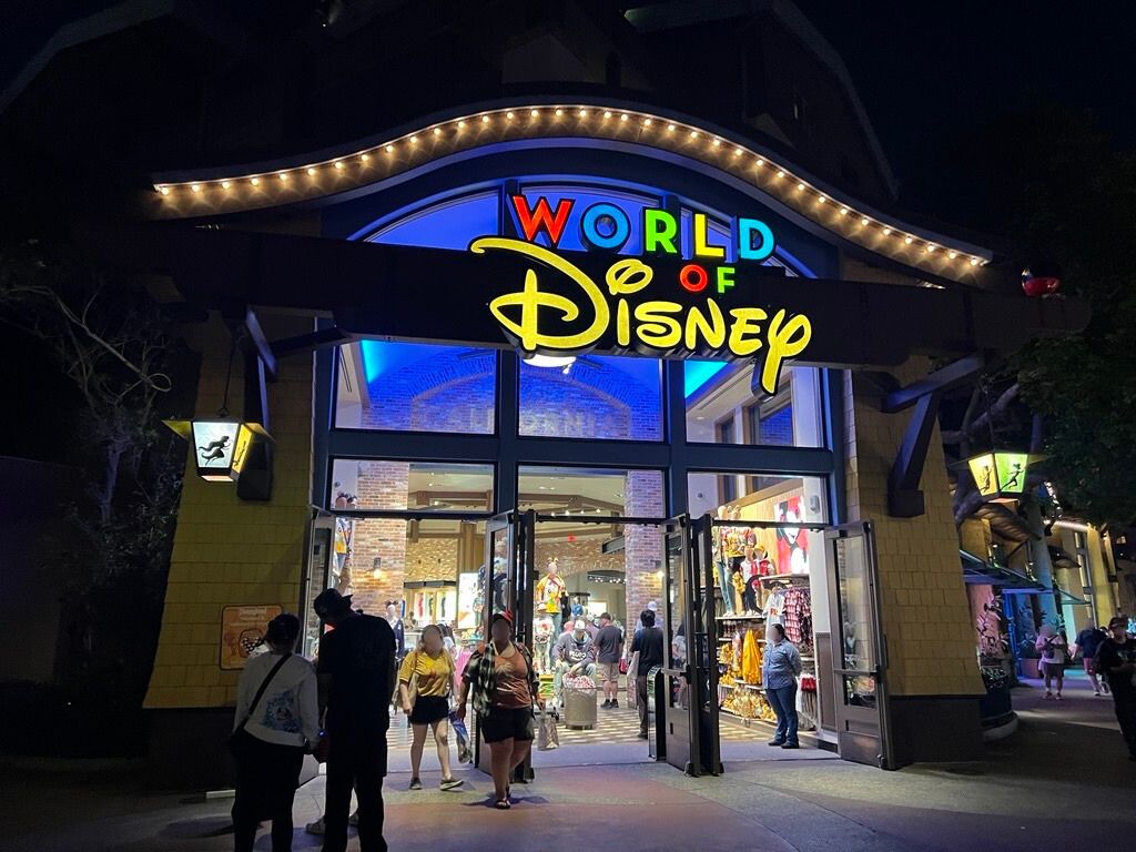 ダウンタウン・ディズニー内の大型ショップ「ワールド・オブ・ディズニー」の夜の外観。店頭には多くのゲストが出入りしている様子。